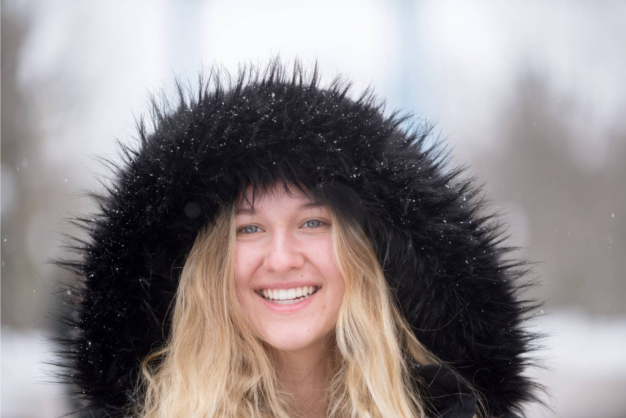 A student smiling in the snow